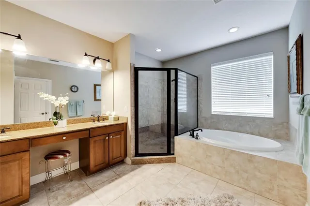a spacious bathroom with a tub sink shower and mirror