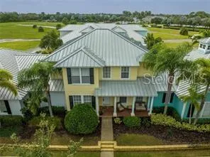 a aerial view of a house with a yard and a floor to ceiling window in the lake