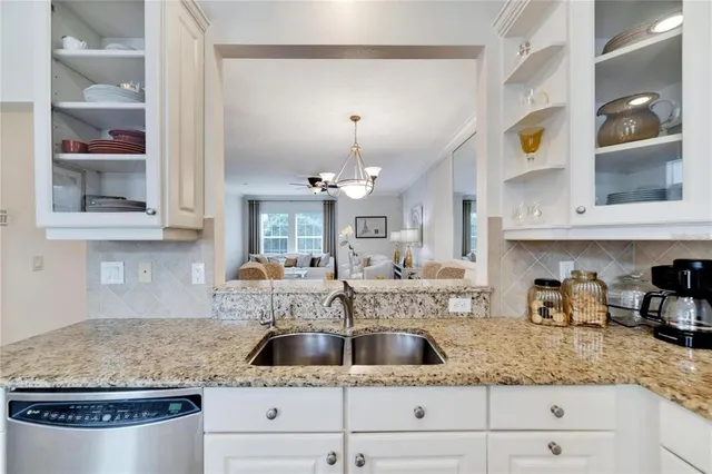 a kitchen with kitchen island granite countertop a sink a stove and cabinets
