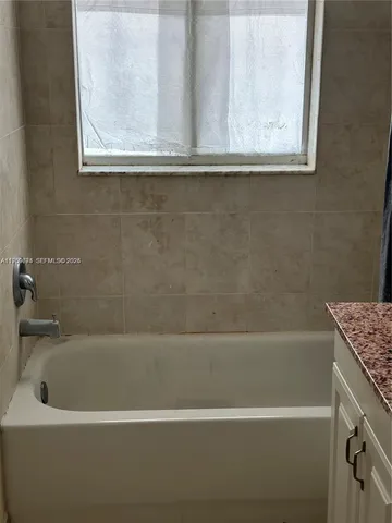 a bathroom with a bathtub window and window