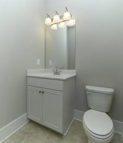 a bathroom with a toilet sink vanity and mirror