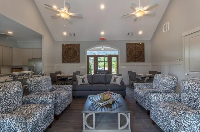 a living room with furniture a ceiling fan and a rug