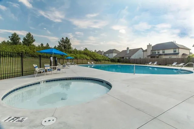 a view of a swimming pool with a table and chairs under an umbrella