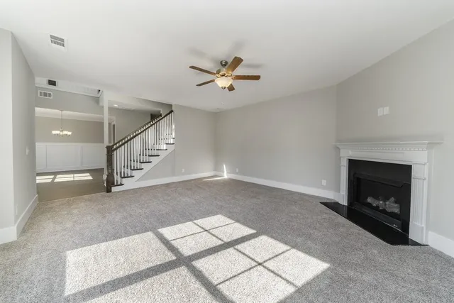 an empty room with windows and fireplace