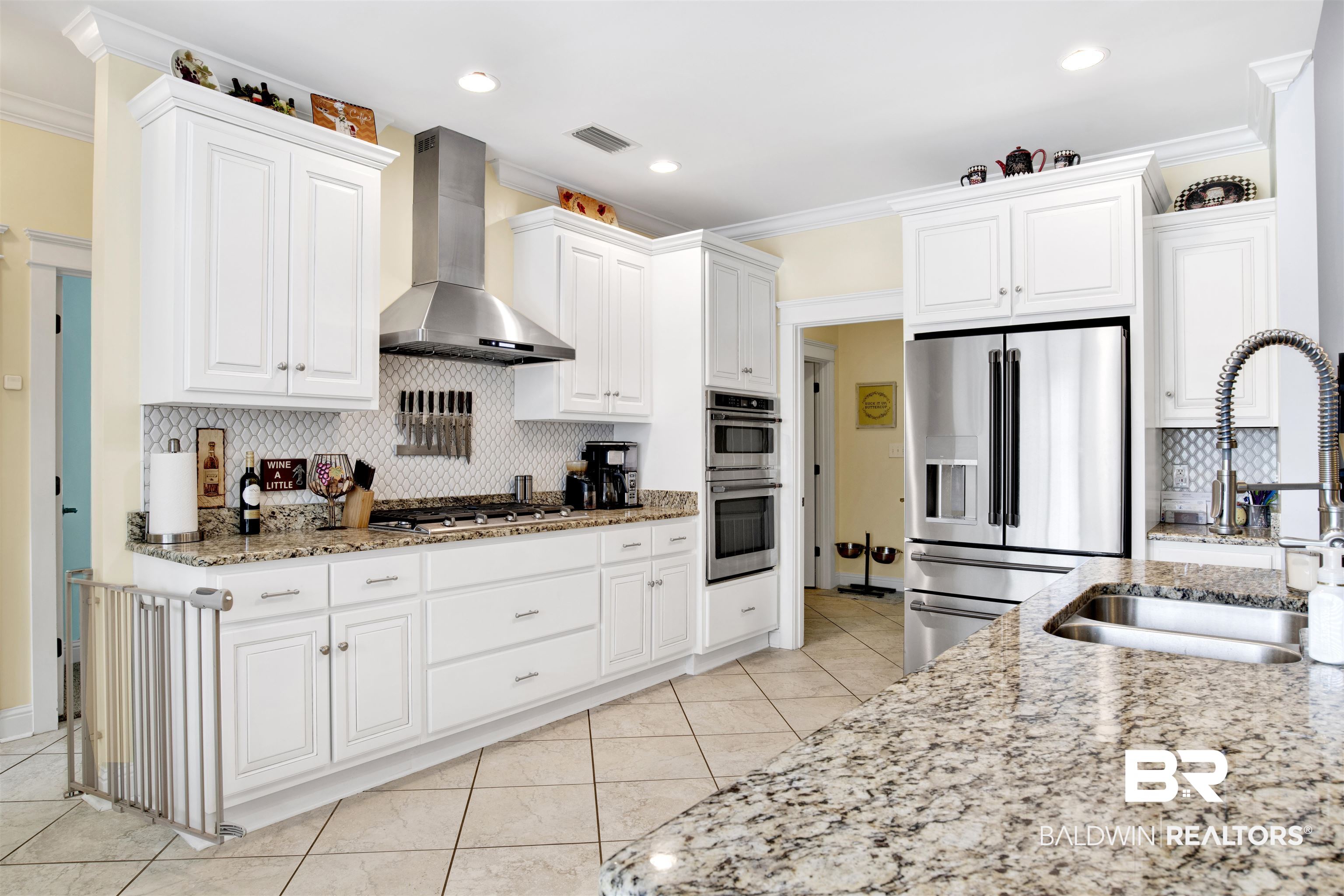 12418 Cambron Trail Daphne, AL 36527 - Photo 22 of 44 Kitchen with appliances with stainless steel finishes, wall chimney exhaust hood, white cabinetry, and sink
