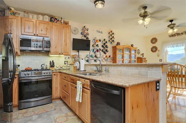 a kitchen with stainless steel appliances granite countertop a sink and a stove