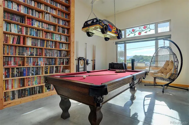 a room with pool table and windows