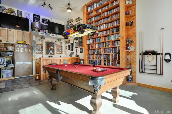 a room with pool table flat screen tv and windows