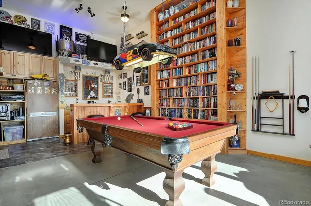 a room with pool table flat screen tv and windows