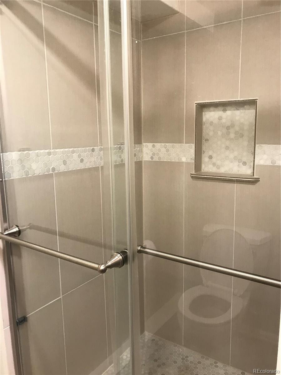 549 Logan Street Denver, CO 80203 - Photo 13 of 14 a bathroom with a glass shower door
