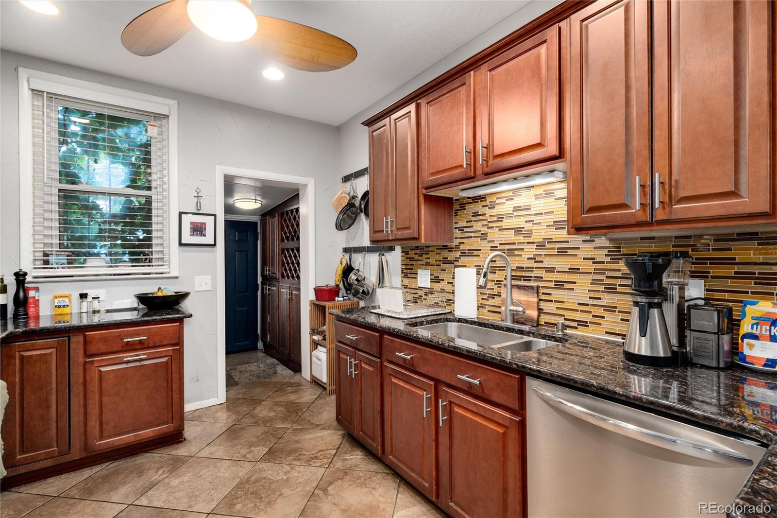 549 Logan Street Denver, CO 80203 - Photo 5 of 14 a kitchen with stainless steel appliances granite countertop a sink stove and cabinets