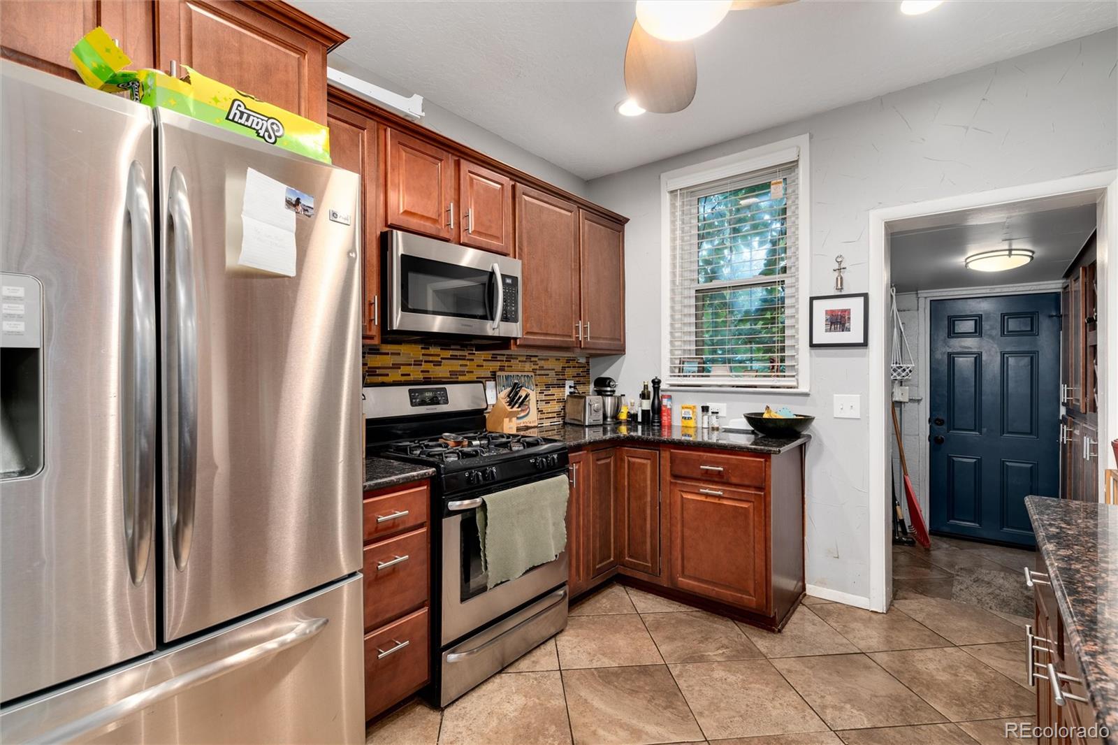 549 Logan Street Denver, CO 80203 - Photo 6 of 14 a kitchen with stainless steel appliances granite countertop a refrigerator a stove top oven a sink and dishwasher