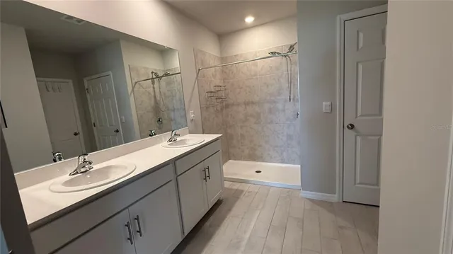 a bathroom with a sink double vanity granite tub and shower
