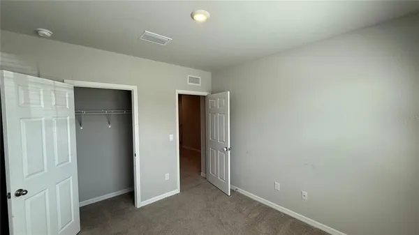 an empty room with closet and wooden door