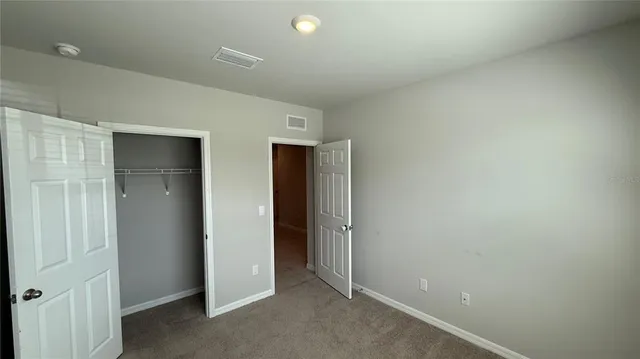 an empty room with closet and wooden door