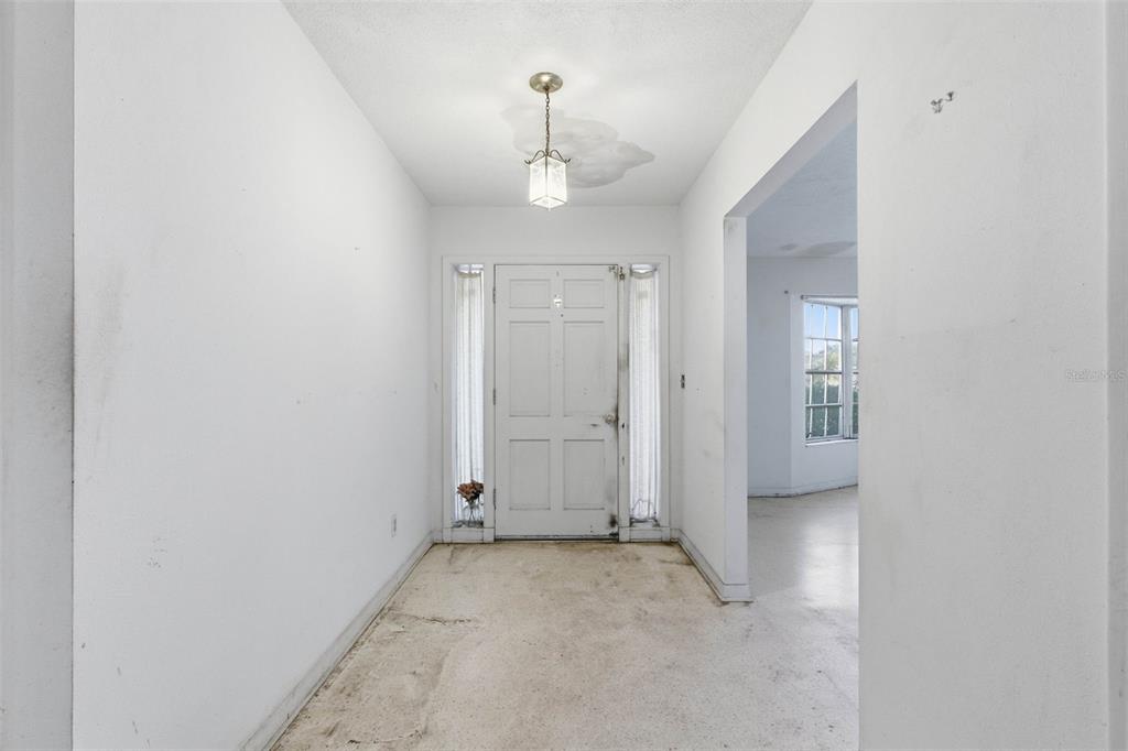 2310 Harrison Drive Dunedin, FL 34698 - Photo 11 of 42 an empty room with an entryway and chandelier