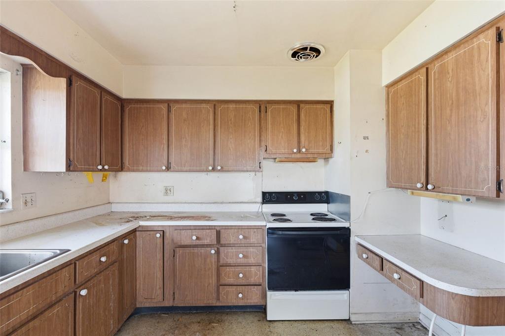 2310 Harrison Drive Dunedin, FL 34698 - Photo 13 of 42 a kitchen with granite countertop white cabinets and white appliances