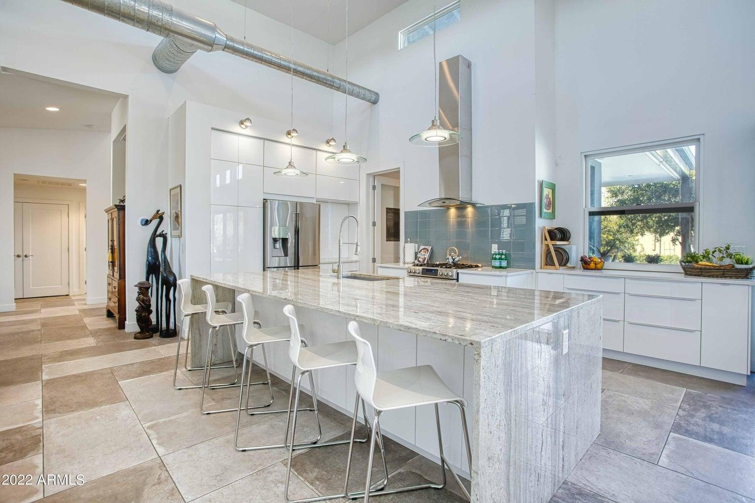 3230 East Colter Street Phoenix, AZ 85018 - Photo 11 of 28 a dining hall with stainless steel appliances kitchen island granite countertop a table and chairs in it