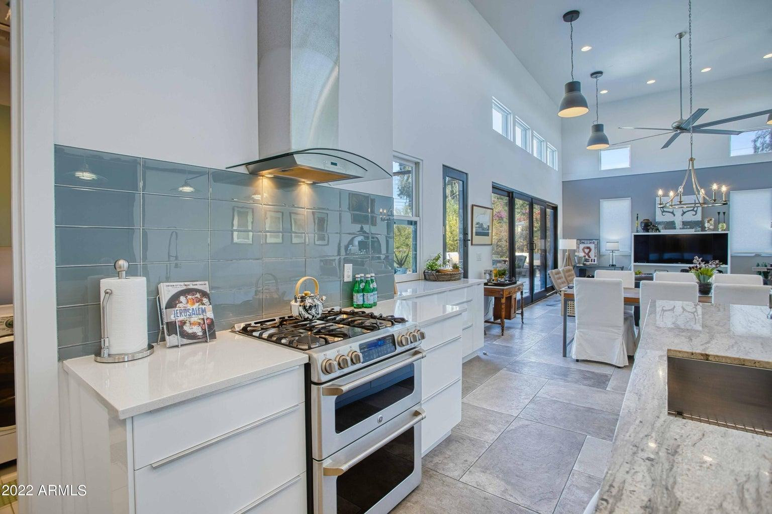 3230 East Colter Street Phoenix, AZ 85018 - Photo 12 of 28 a kitchen with stainless steel appliances kitchen island granite countertop a stove a sink and a refrigerator