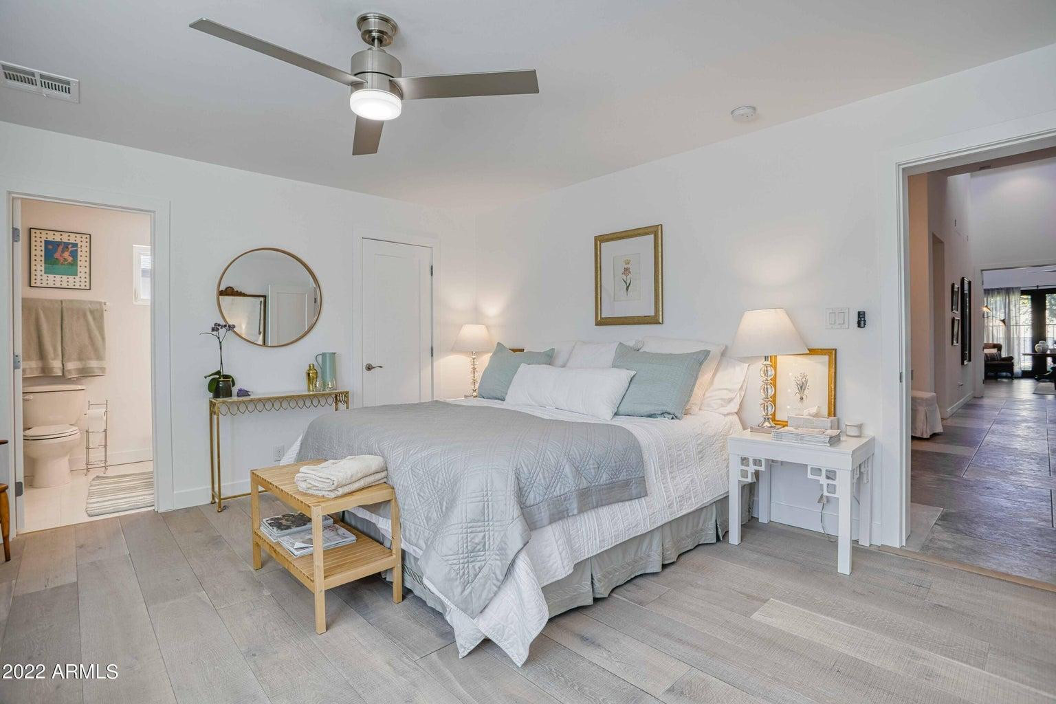 3230 East Colter Street Phoenix, AZ 85018 - Photo 18 of 28 a spacious bedroom with a bed a chandelier and dresser
