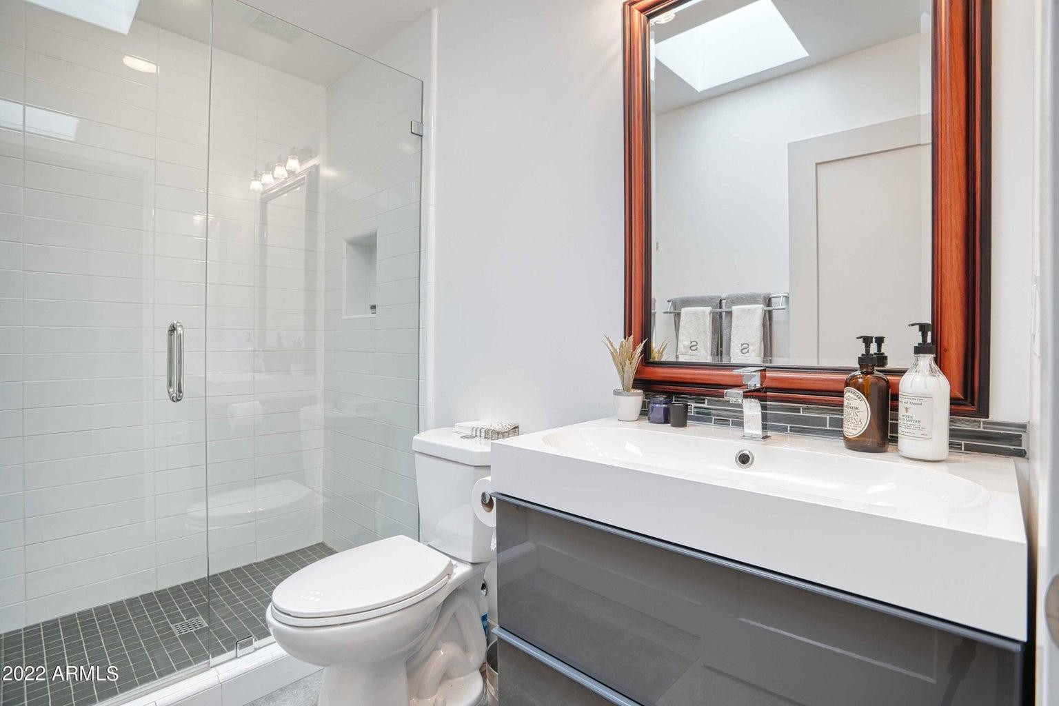3230 East Colter Street Phoenix, AZ 85018 - Photo 21 of 28 a bathroom with a sink toilet a mirror and shower