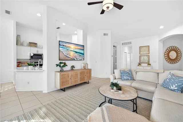 a living room with furniture and a dining table with wooden floor