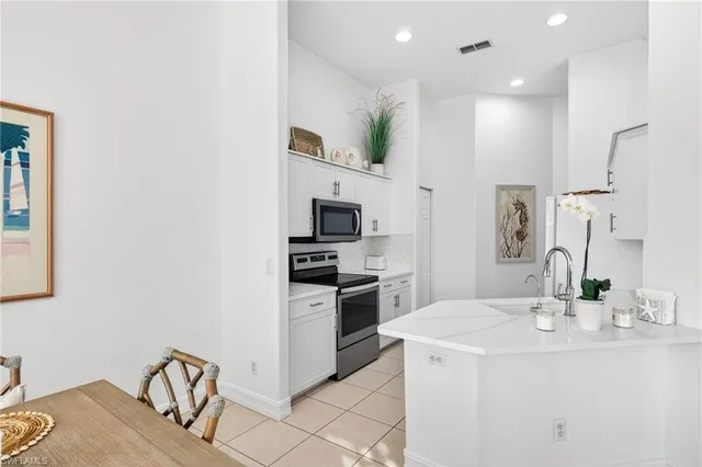 a kitchen with kitchen island granite countertop a sink appliances cabinets and furniture