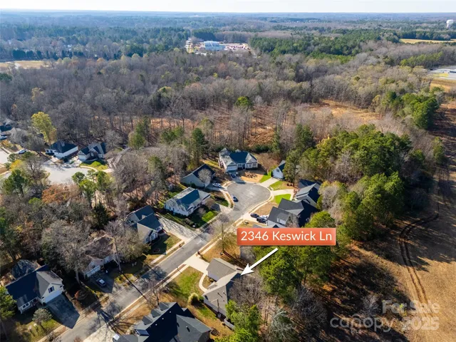 an aerial view of a house with a yard and mountain
