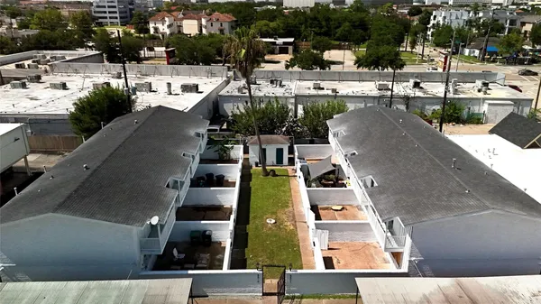 an empty room with wooden floor a ceiling fan and windows
