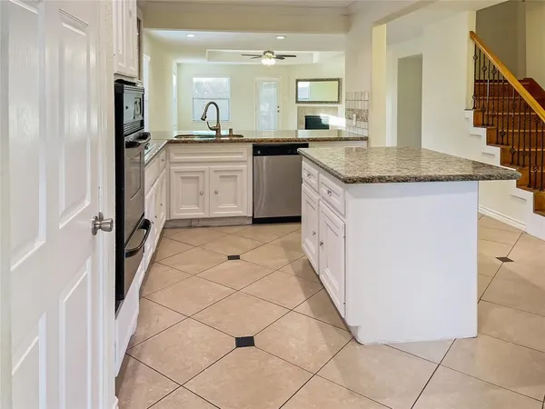 a kitchen with granite countertop a sink and cabinets