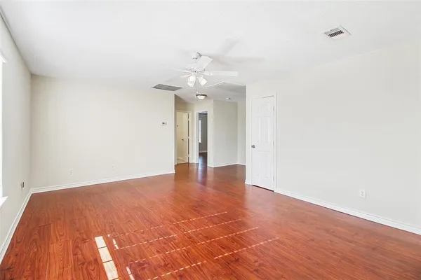 a view of an empty room with wooden floor