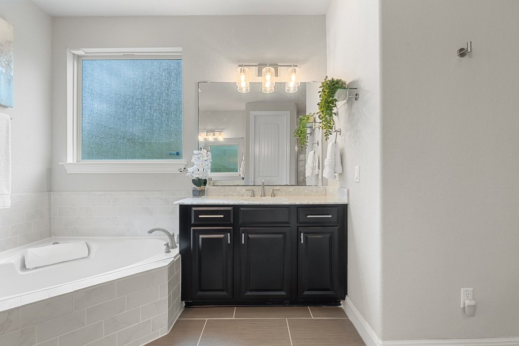 4229 Borho Ranch Street Leander, TX 78641 - Photo 15 of 40 Bathroom with vanity, a bath, and light tile patterned floors