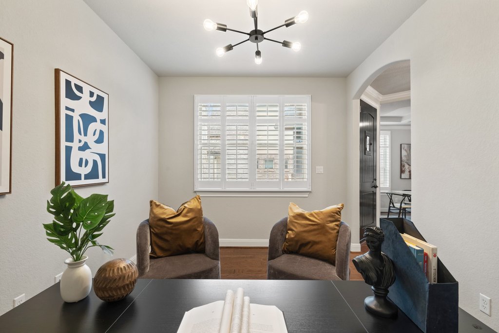 4229 Borho Ranch Street Leander, TX 78641 - Photo 18 of 40 Dining room featuring arched walkways, wood finished floors, and a chandelier