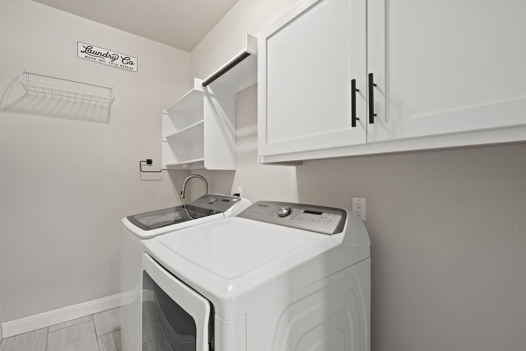 4229 Borho Ranch Street Leander, TX 78641 - Photo 29 of 40 Laundry room with cabinet space and washer and dryer