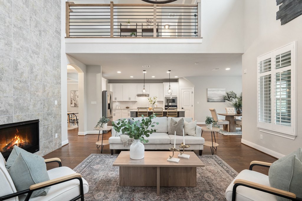 4229 Borho Ranch Street Leander, TX 78641 - Photo 3 of 40 Living room with a high ceiling, dark wood-type flooring, a fireplace, arched walkways, and recessed lighting