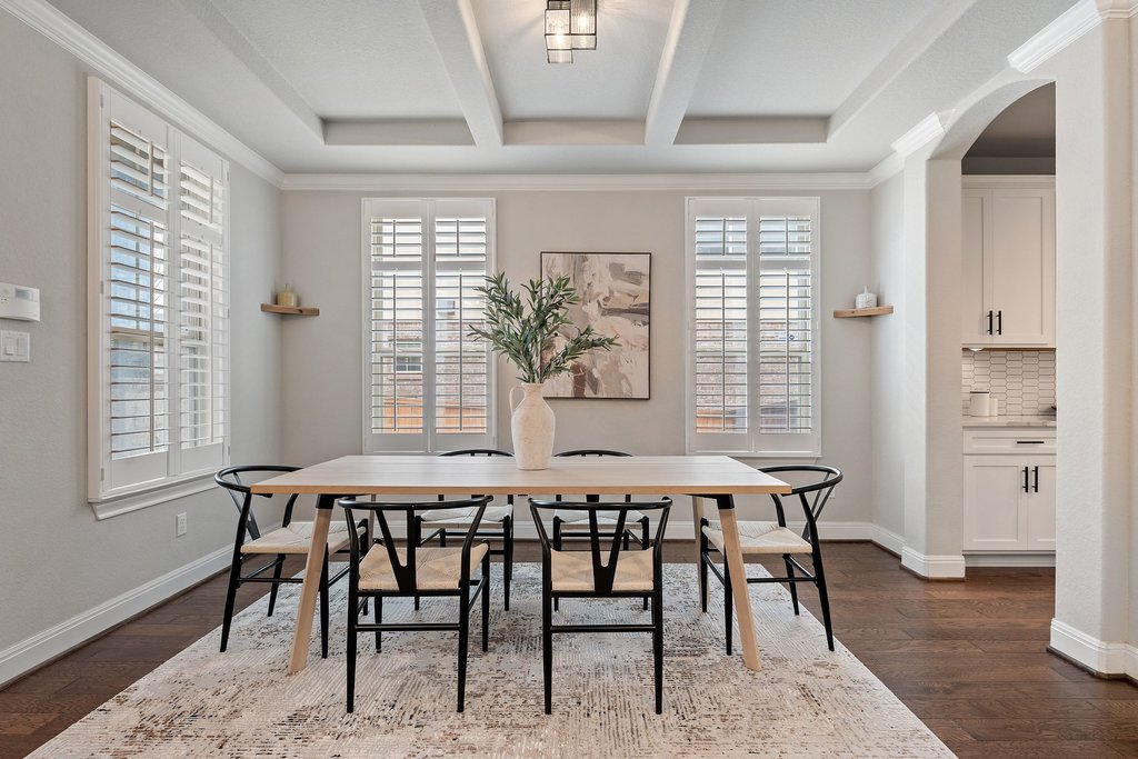 4229 Borho Ranch Street Leander, TX 78641 - Photo 6 of 40 Dining space featuring dark wood-style flooring, ornamental molding, arched walkways, and beam ceiling