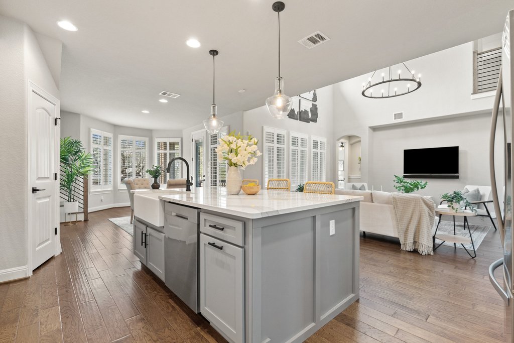 4229 Borho Ranch Street Leander, TX 78641 - Photo 40 of 40 Kitchen featuring open floor plan, arched walkways, a kitchen island with sink, gray cabinets, and dark wood finished floors