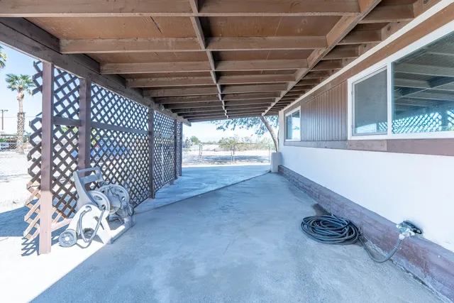 a backyard of a house with table and chairs under an umbrella