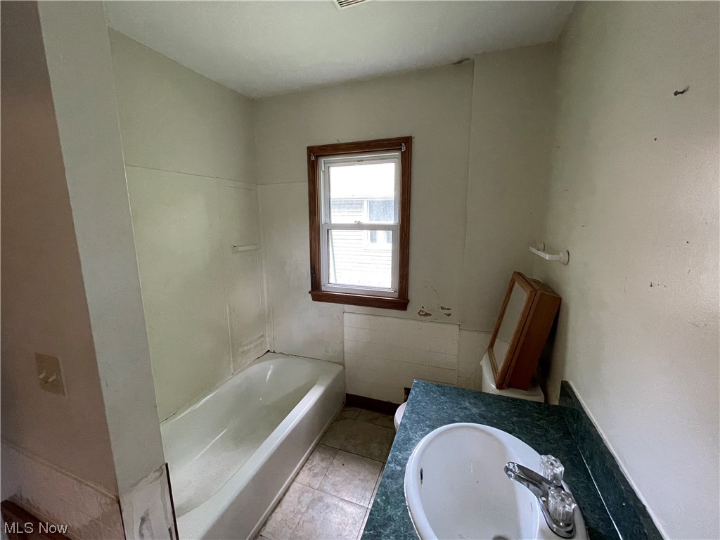 829 Berwin Street Akron, OH 44310 - Photo 15 of 24 Bathroom with shower / washtub combination, sink, and light tile floors