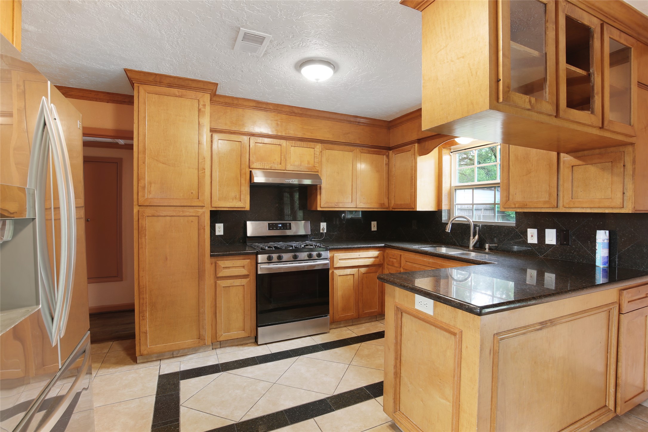 6923 Leader Street Houston, TX 77074 - Photo 13 of 19 a kitchen with stainless steel appliances granite countertop a stove a refrigerator and a sink