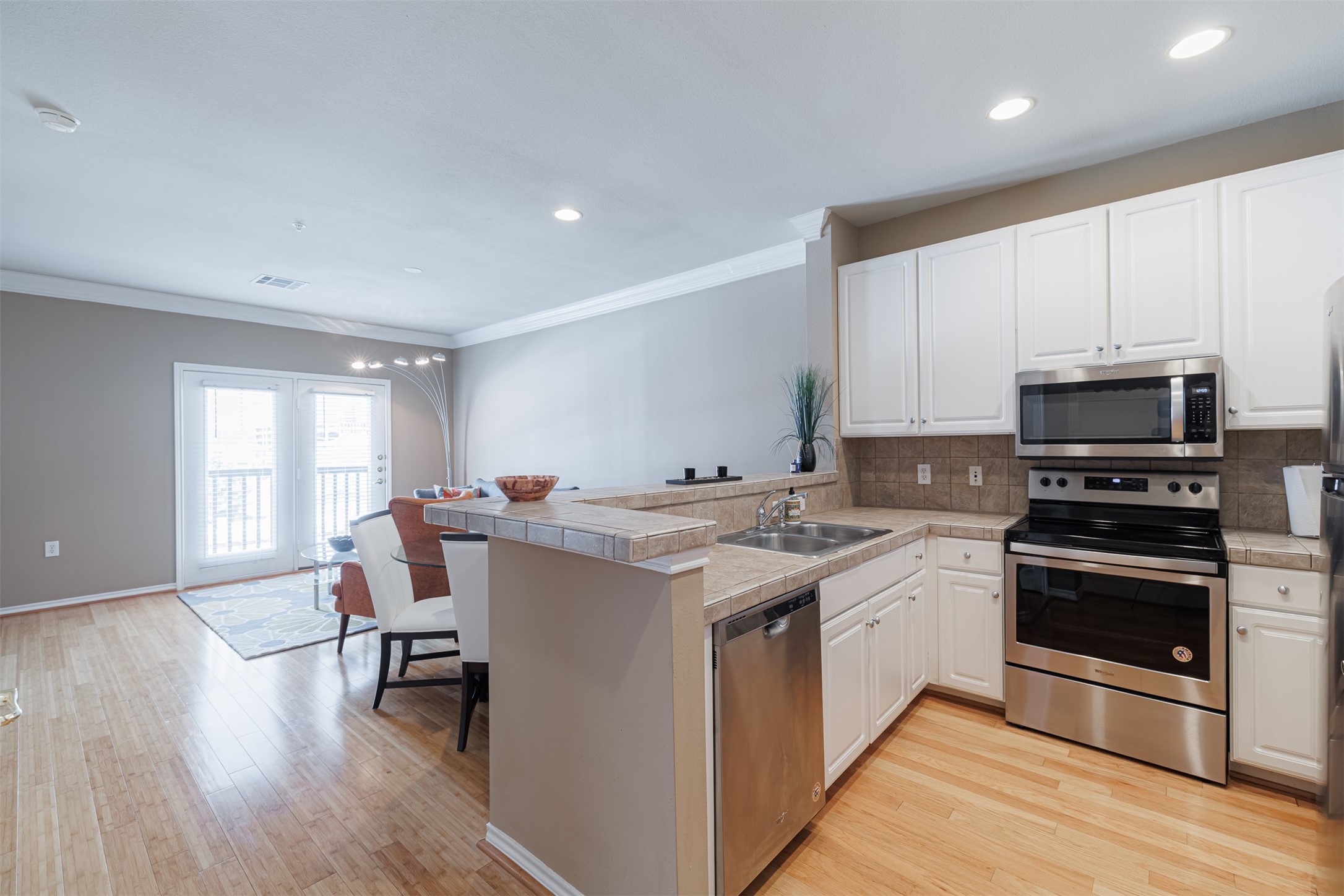 2400 McCue Road, Unit 348 Houston, TX 77056 - Photo 1 of 24 a kitchen with stainless steel appliances a stove top oven a sink dishwasher and a refrigerator with wooden floor