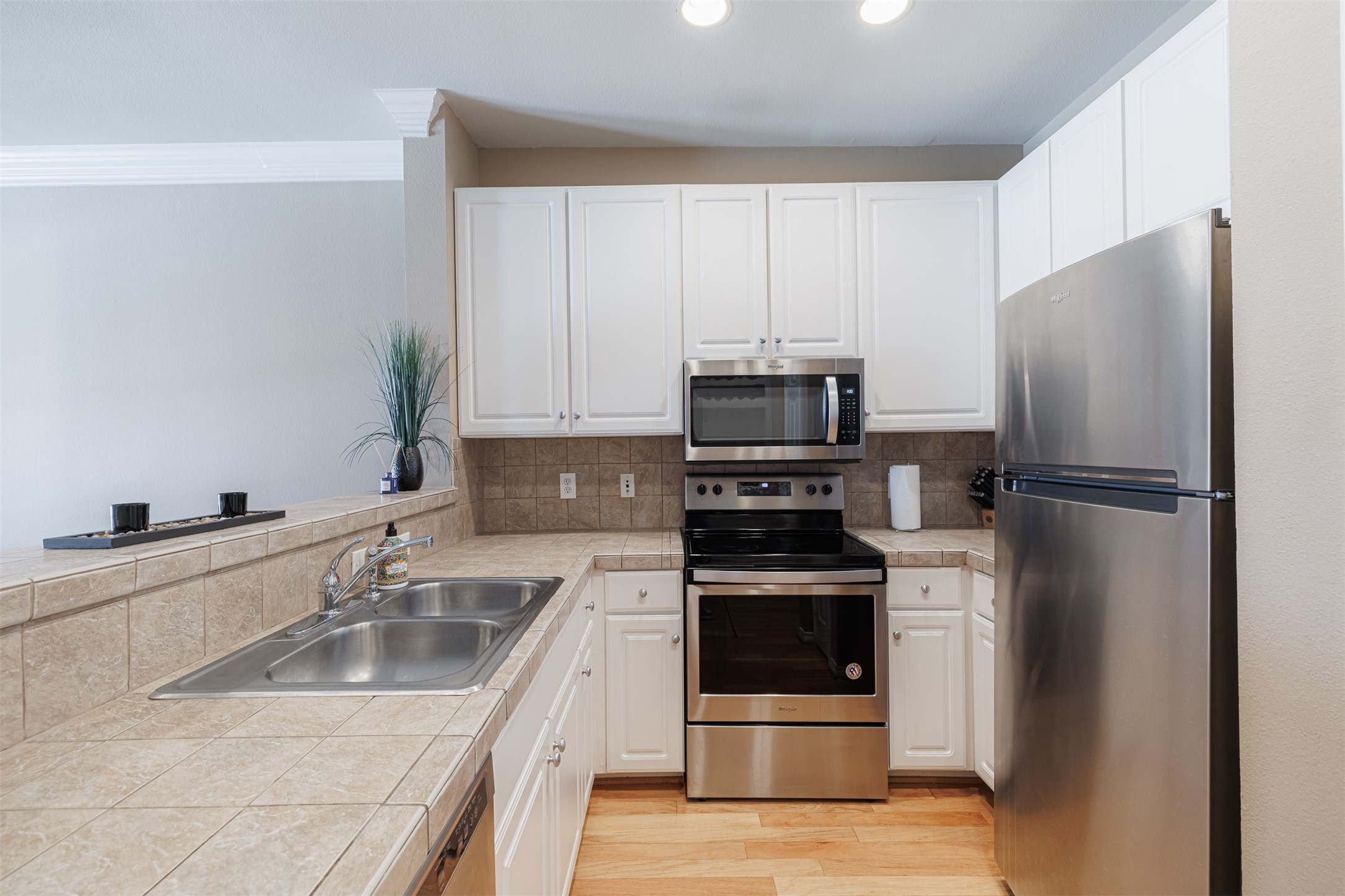 2400 McCue Road, Unit 348 Houston, TX 77056 - Photo 2 of 24 a kitchen with a refrigerator sink and white cabinets