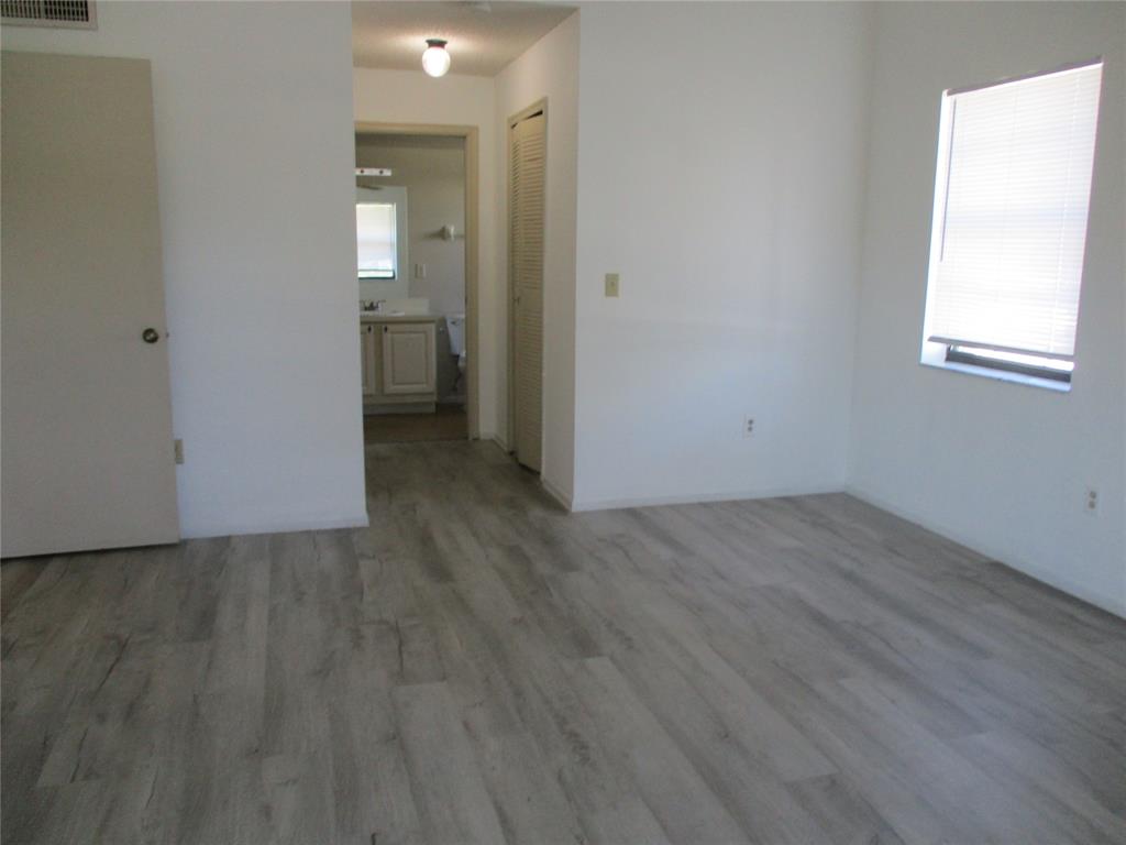 23442 Southwest 57th Avenue, Unit 406 Boca Raton, FL 33428 - Photo 15 of 25 an empty room with wooden floor and windows