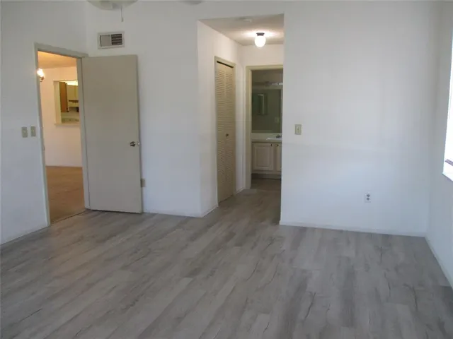 an empty room with wooden floor and closet