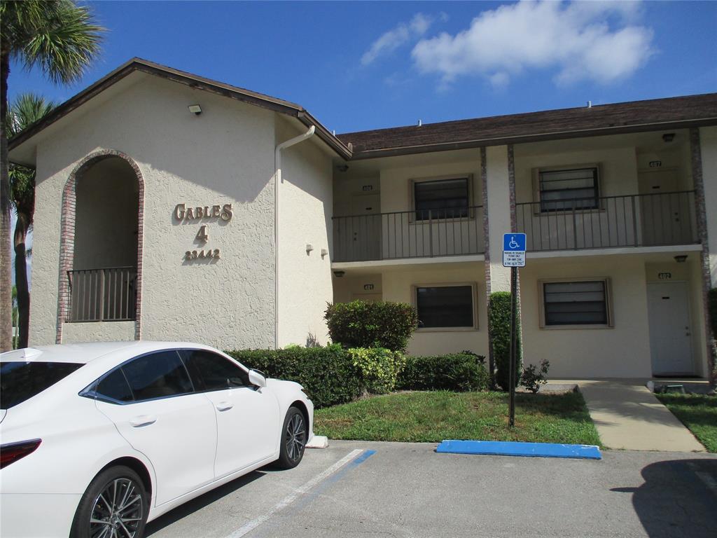 23442 Southwest 57th Avenue, Unit 406 Boca Raton, FL 33428 - Photo 24 of 25 a front view of a house with a yard and garage