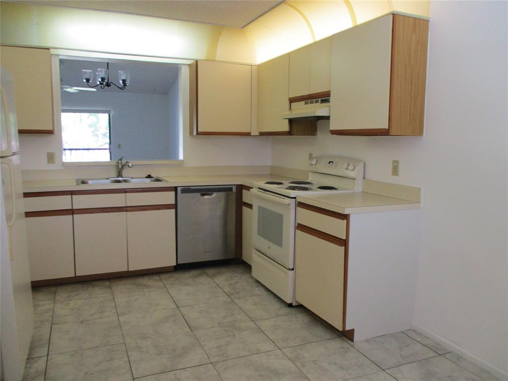 23442 Southwest 57th Avenue, Unit 406 Boca Raton, FL 33428 - Photo 4 of 25 a kitchen with a sink stove and microwave