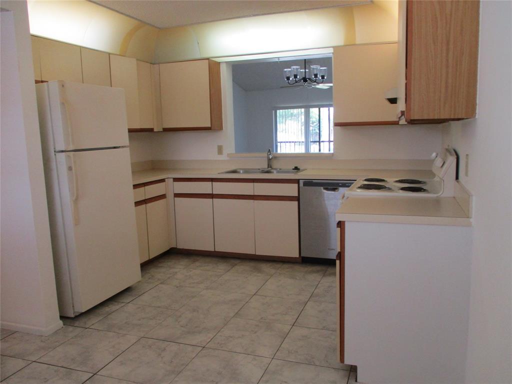 23442 Southwest 57th Avenue, Unit 406 Boca Raton, FL 33428 - Photo 5 of 25 a kitchen with stainless steel appliances granite countertop a sink stove and refrigerator