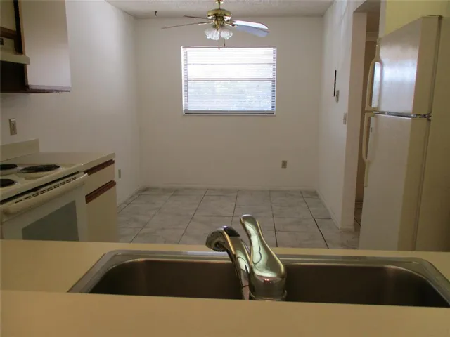 a view of a kitchen counter space a sink wooden floor and a stove top oven