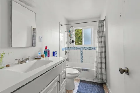 a bathroom with a sink toilet vanity and tub