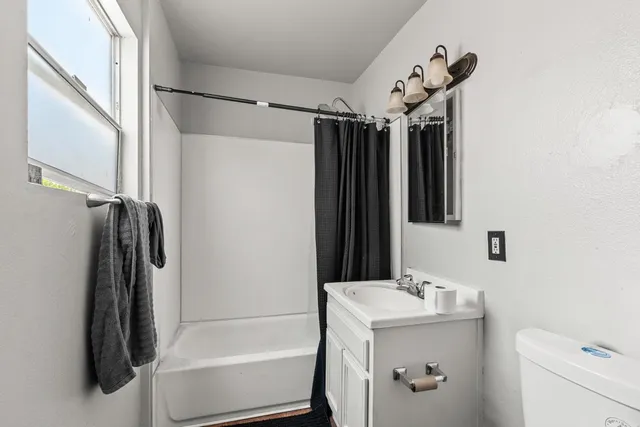 a bathroom with a tub sink and a shower curtain
